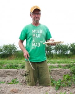 Søren Wiuff standing between the banks of his asparagus field.