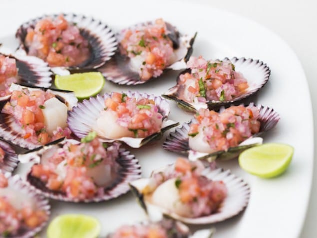 For a refreshing appetizer, serve fresh scallops with a bright onion, tomato, and lime juice topping.