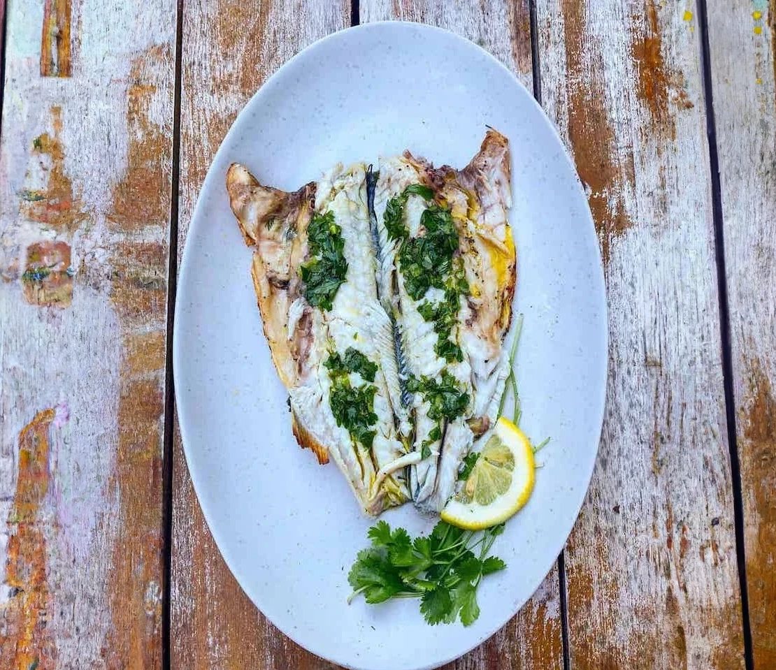 Whole branzino, stuffed with herbs and lemons, quickly touched by the flames of the grill, and served with lemon and herb infused olive oil. 