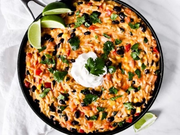 This Cheesy Enchilada Orzo is the perfect addition to your next Tex-Mex dinner. It is loaded with corn, pepper, black beans, cilantro, and cheese.