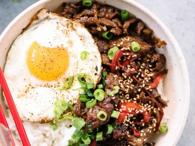 A fluffy pile of rice topped with sweet and salty thinly-sliced beef and caramelized onions that have been simmered together in sesame oil and beef stock. Add on a runny-yolk fried egg, sesame seeds, and freshly chopped green onion and you are in for some great flavor in these Japanese Beef and Rice Gyudon Bowls.