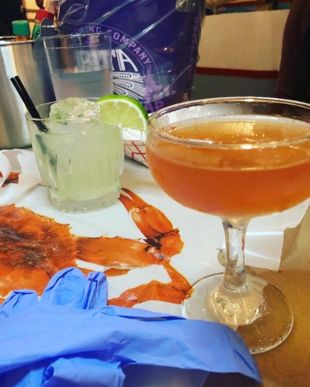 Spicy Margarita and a Sazerac with a lobster bib and gloves. Everything you need for a New Orleans seafood boil.