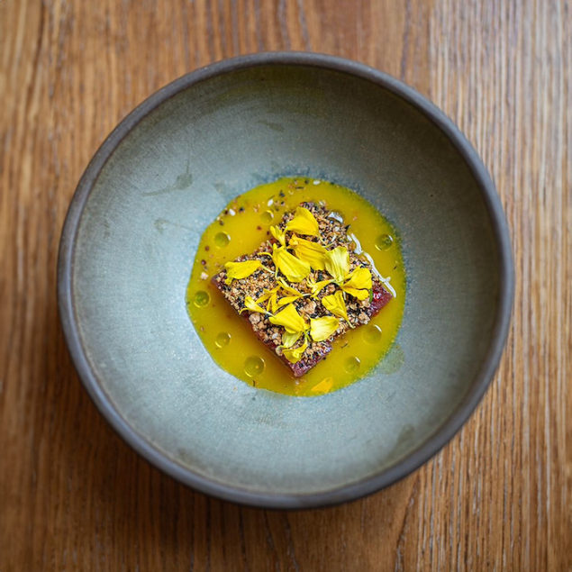 A vibrant Japanese-Peruvian inspired ceviche, where watermelon and tuna is quickly marinated in Yuzu Aji Amarillo Tiger's Milk, and topped with edible flowers.