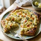 Open puff pastry tart topped with mashed potato, leeks, capers and cheese